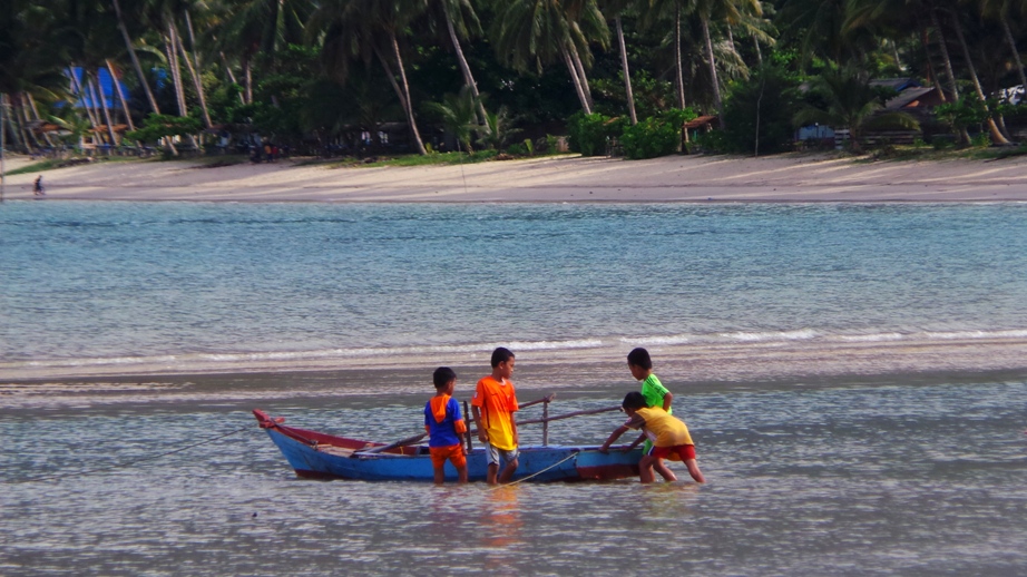 Empat orang anak-anak bermain perahu di Pantai Tanjung, Kecamatan Bunguran Timur Laut. Potensi wisata di pesisir timur Natuna terancam mati suri karena lahan-lahan di sepanjang pantai sudah dimiliki pengusaha dan pejabat.